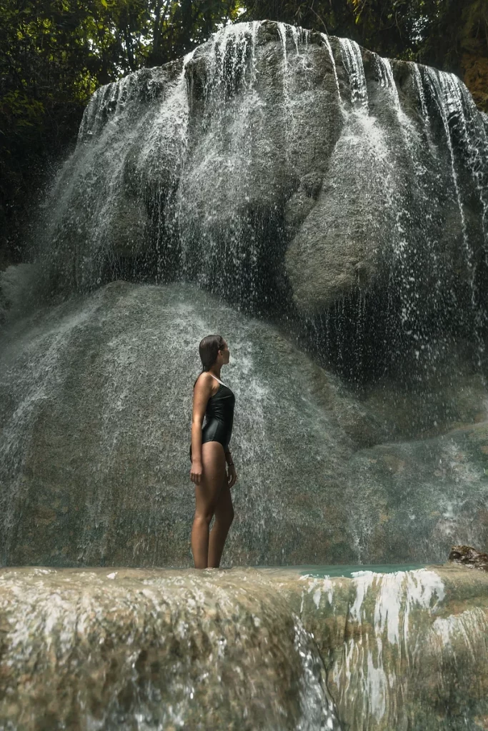 Climbing the multi-tiered Aguinid Falls in Cebu, surrounded by lush greenery.