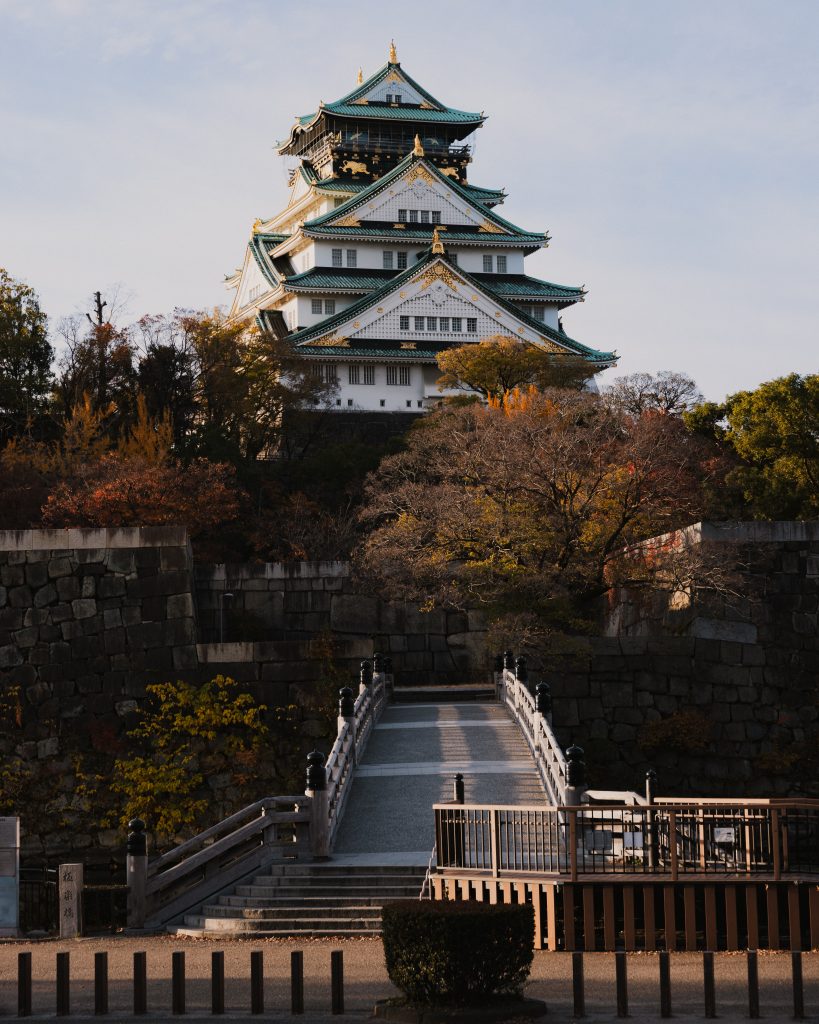 Osaka Castle surrounded by a canopy of golden and red leaves, a must-see destination during autumn in Japan.thpara