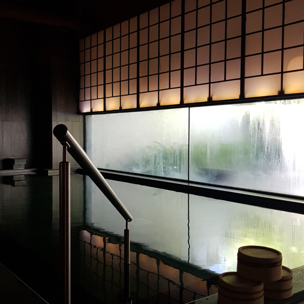 A stunning outdoor bath surrounded by lush greenery and mountains.