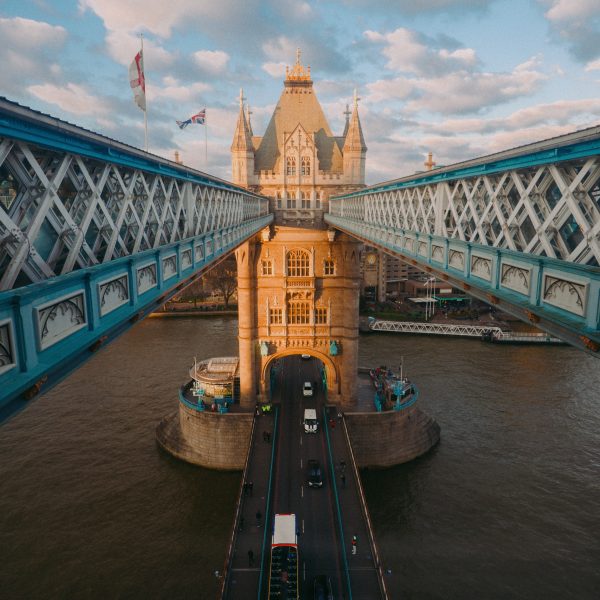 Historic image of Tower Bridge with its neo-Gothic towers and bascules raised for a passing ship.