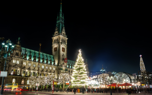 View of Rathausmarkt Christmas Market in Hamburg with festive lights, wooden stalls, and a large Christmas tree