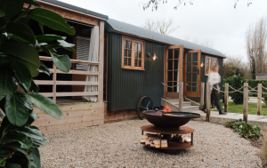 Lake Hut Primrose at Tewinbury Farm Stay surrounded by trees beside the water