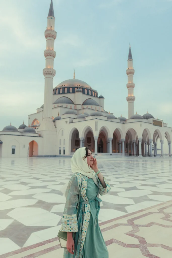 Helena wearing a headscarf and abaya in the courtyard of Sharjah Mosque